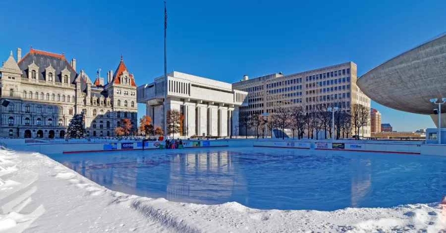 New York State Capitol building in the winter behind Empire State Plaza ice rink